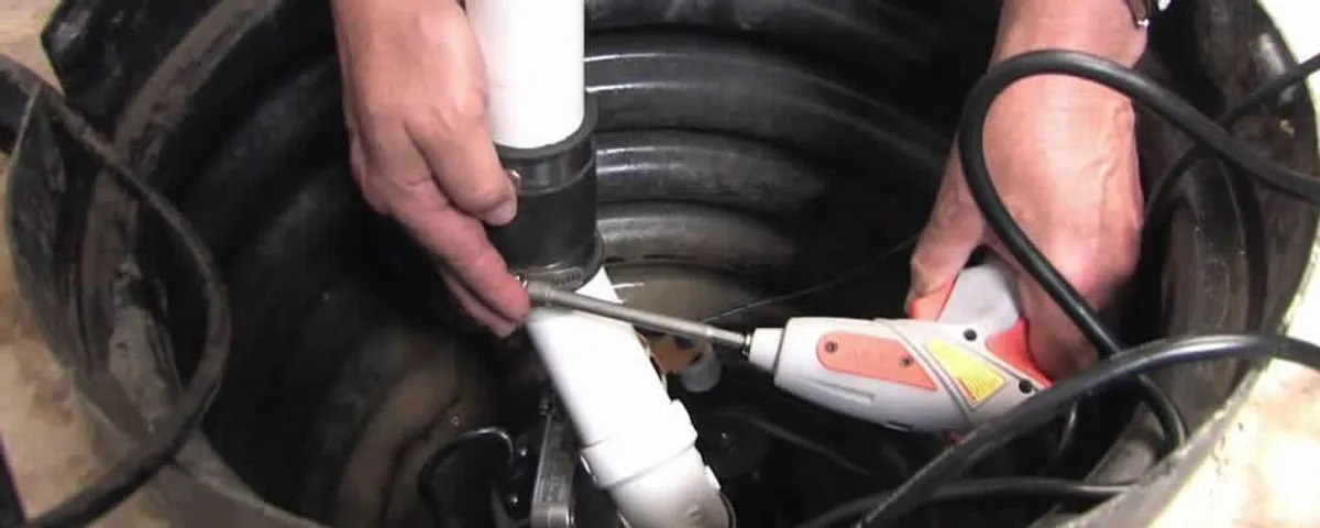Sump pump installation technician connecting PVC discharge piping in Bakersfield, CA